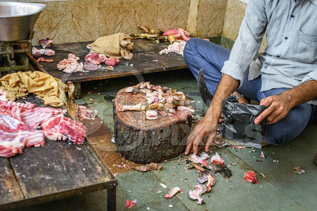 Meat shop worker chopping up goat or mutton in a mutton shop, Jodhpur, Rajasthan, India, 2022