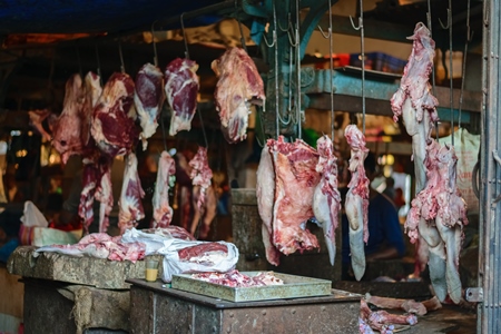 Pieces of meat hanging up from hooks at Crawford meat market in Mumbai