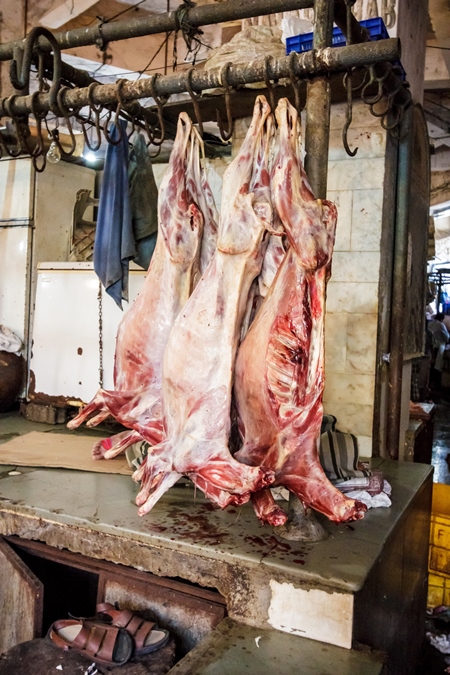 Goat meat hanging up at mutton shops in Crawford meat market, Mumbai, India, 2016