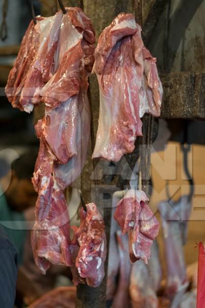 Pieces of buffalo meat hanging on hooks inside Crawford meat market in Mumbai, India, 2016