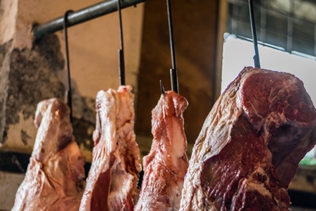 Pieces of meat hanging up from hooks at Crawford meat market in Mumbai