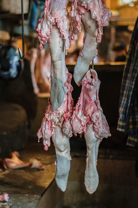 Pieces of meat hanging up from hooks at Crawford meat market in Mumbai