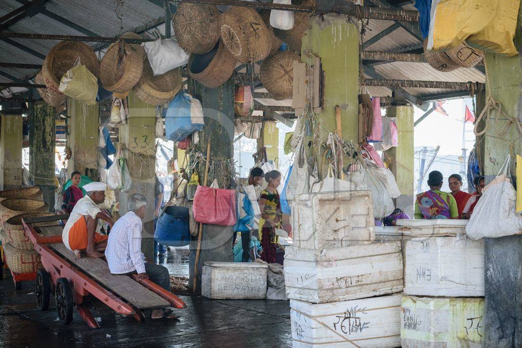 People at a fish market with boxes of fish on sale at a fish market at a fish market at Sassoon Docks