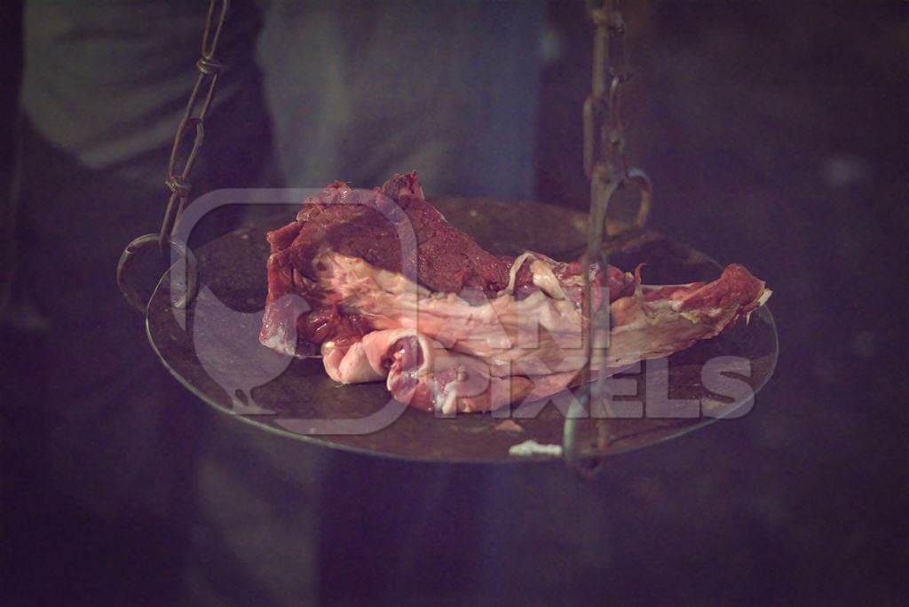 Weighing scale with pieces of buffalo meat inside Crawford meat market in Mumbai in dark conditions, 2016