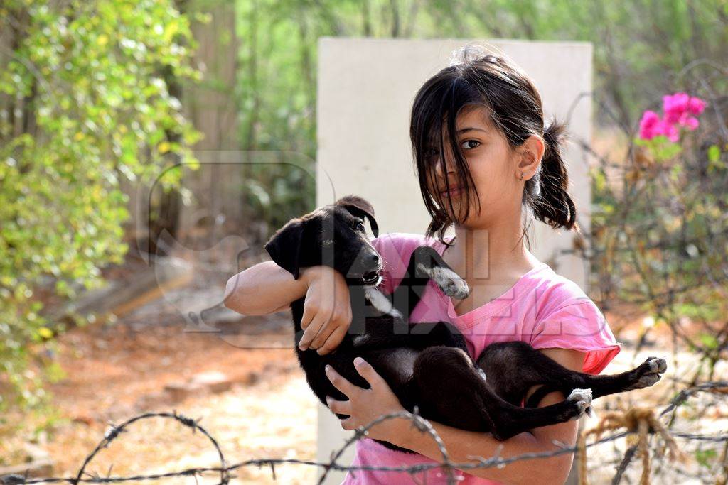 Girl child holding cute puppy dog