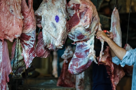 Pieces of meat hanging up from hooks at Crawford meat market in Mumbai