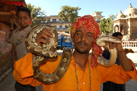 Man in orange holding snake around his neck